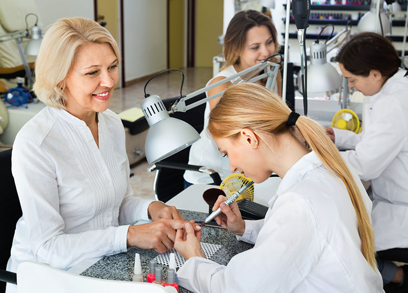 Prezent na dzień mamy: kobieta podczas manicure w salonie manicure.