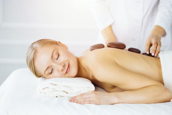 A woman getting a hot stone massage.