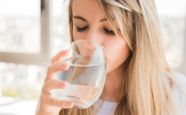 bride drinking water for pre-wedding facial treatment