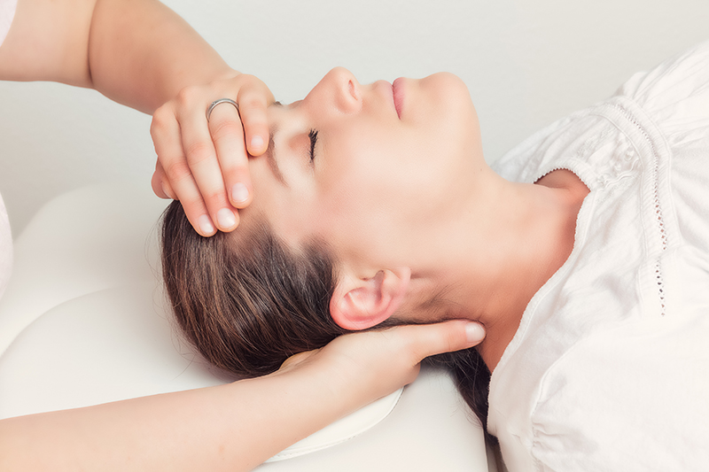 Fizjoterapia - twarz pacjentki i dłonie fizjoterapeuty