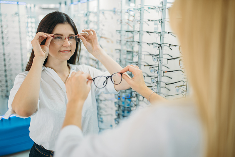 Kobieta przymierzająca okulary u optyka